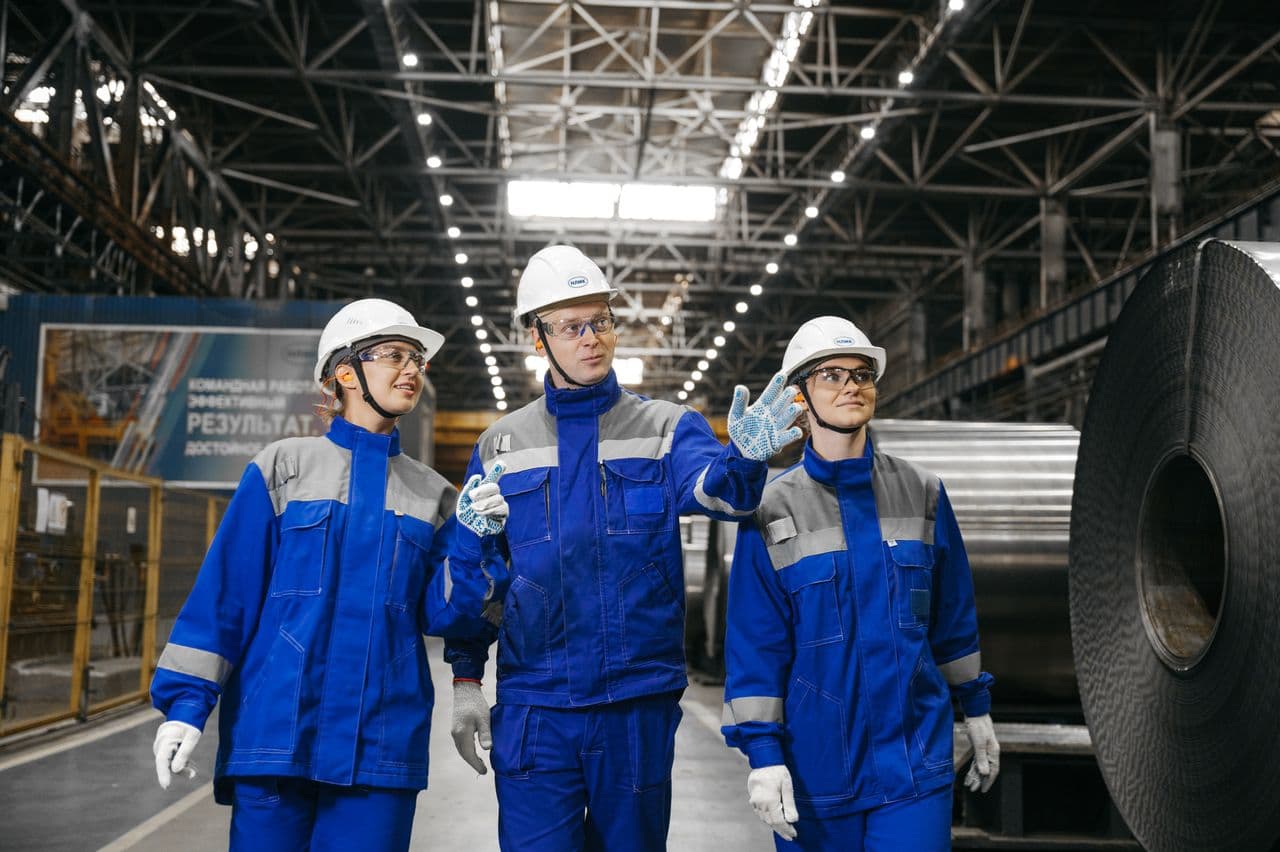Engineers in safety gear walking through a steel plant