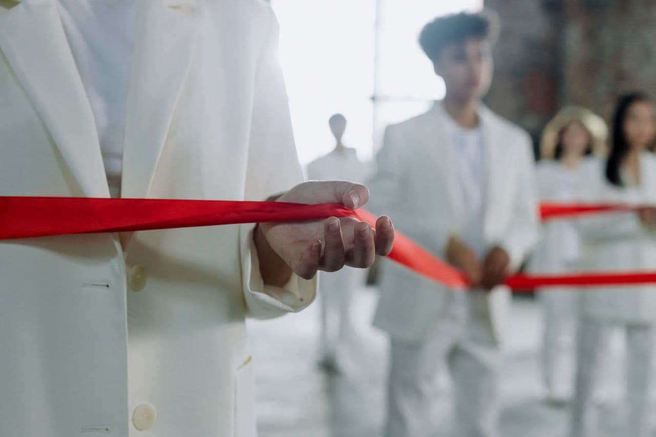 Guest holding a red ceremonial ribbon at an opening